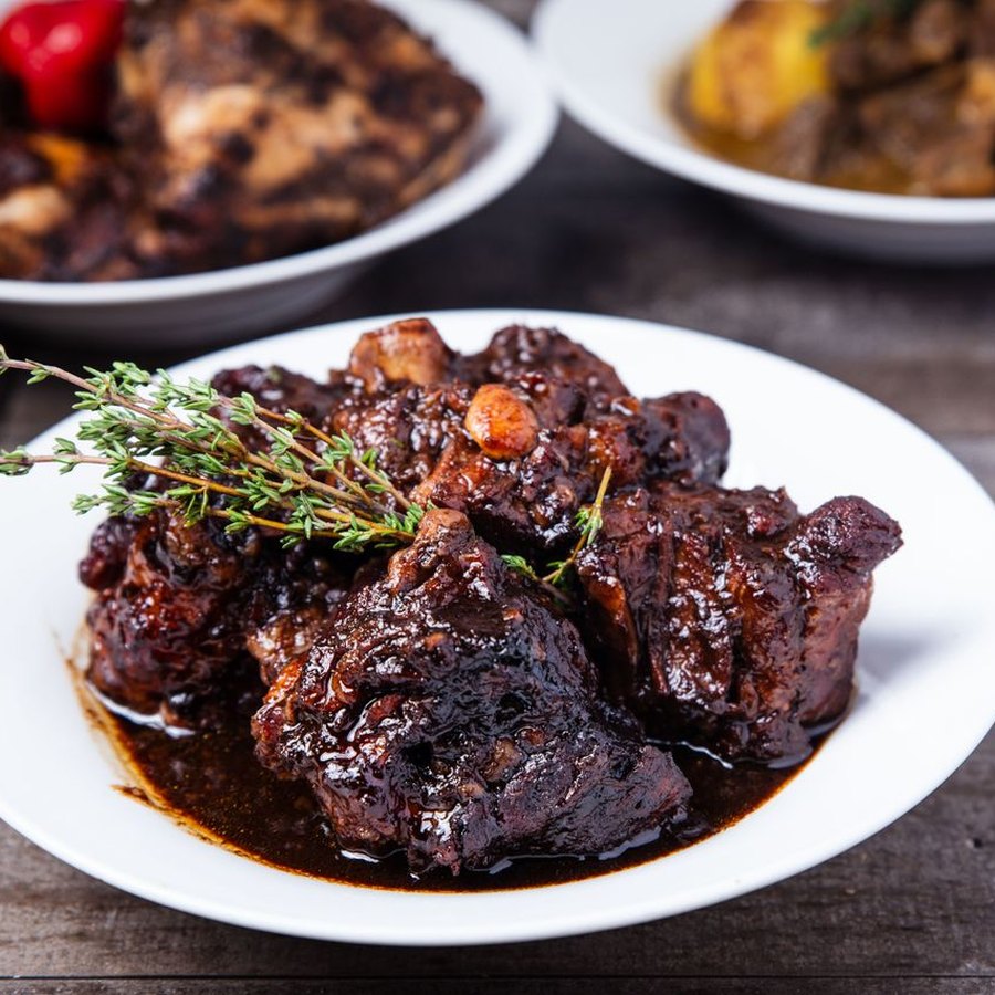 Braised oxtails in glossy brown gravy over rice